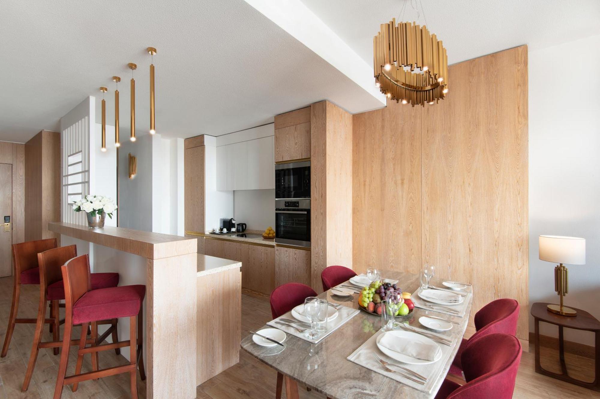 The Bentley Luxury Hotel & Suites Doha Exterior foto A kitchen and dining room in a typical apartment